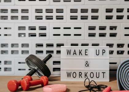 Fitness gear and motivational sign in home gym setup against a brick wall.